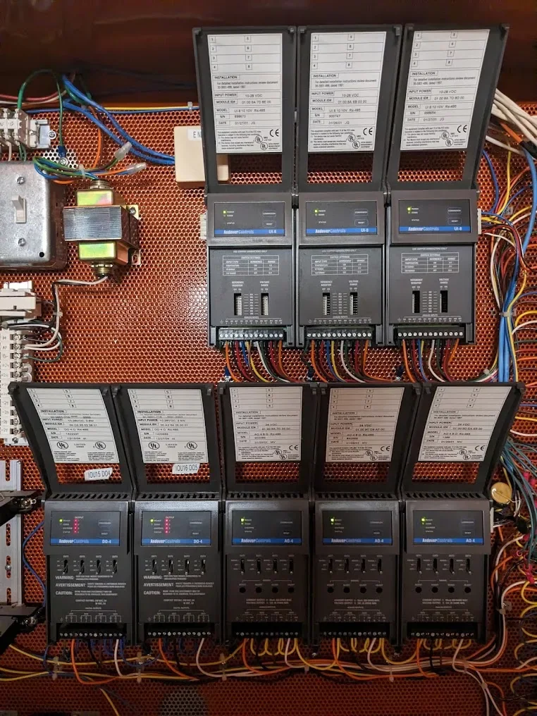Building control panel containing Andover Controls modules and connected wiring